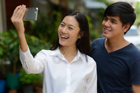 年轻英俊的菲律宾男子和年轻美丽的亚洲女在街上露图片