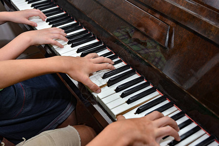 介绍钢琴素材四只手弹钢琴的钢琴键上最顶端的手视线音背景