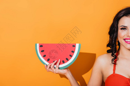 快乐的女人拿着剪纸西瓜放在橘子上的剪影图片