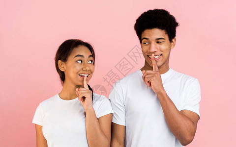 惊讶的青少年夫妇做沉默的手势图片