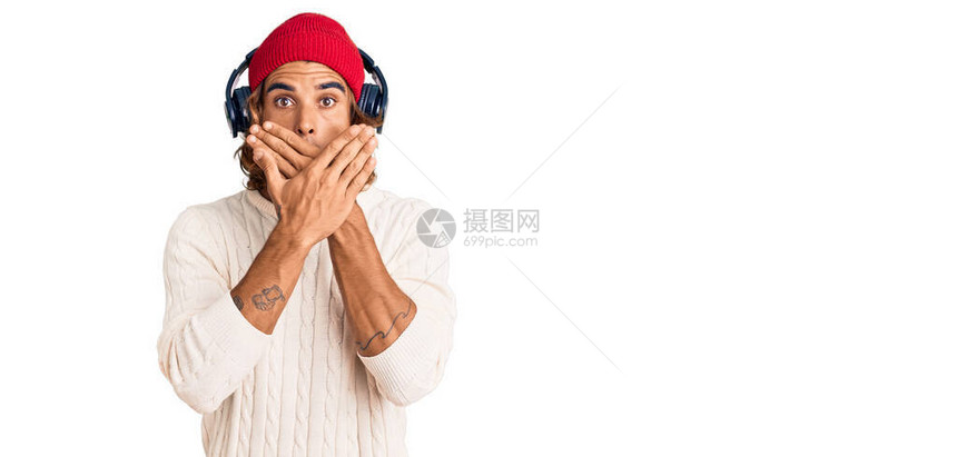 用耳机监听音乐的黑人年轻人用手顶住嘴对错误大惊小怪图片
