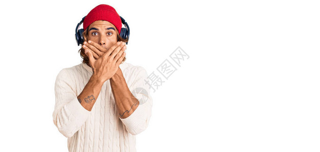 用耳机监听音乐的黑人年轻人用手顶住嘴对错误大惊小怪图片