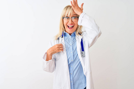 中年医生女人戴着眼镜和听诊器在孤立的白色背景上惊讶地用手在头上犯错图片