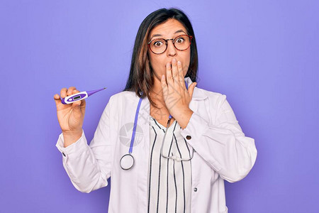 职业医生女在紫色背景上展示医用温度计图片