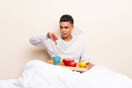 年轻人在床上吃早餐时图片