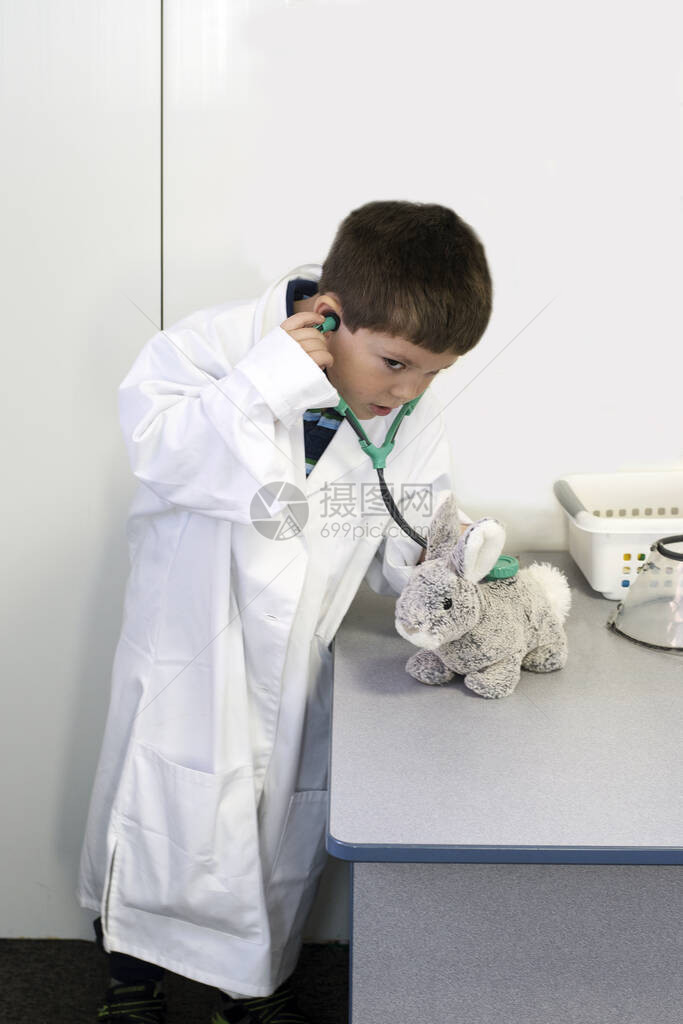 一位年轻的动物医生在他的兽医办公室听图片