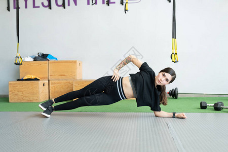 在交叉训练健身房做侧木板运动的坚定图片