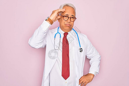 身穿听诊镜和专业医疗大衣的老年灰色头发医生男子图片