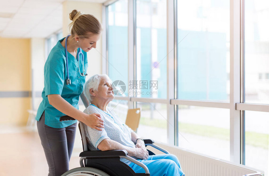坐在轮椅上的高级妇女和医院的护士图片