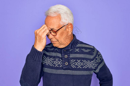 中年白发老人戴着眼镜和紫色背景的冬季毛衣图片