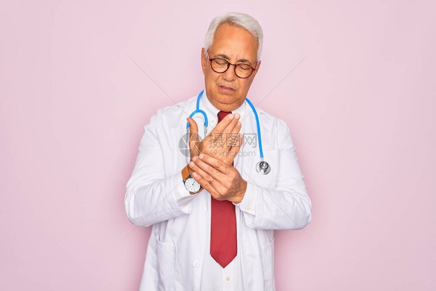戴听诊器和专业医用外套的中年老白发医生手和指疼痛图片