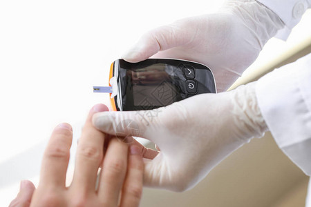在诊所检查糖尿病患者血糖水平的医生图片