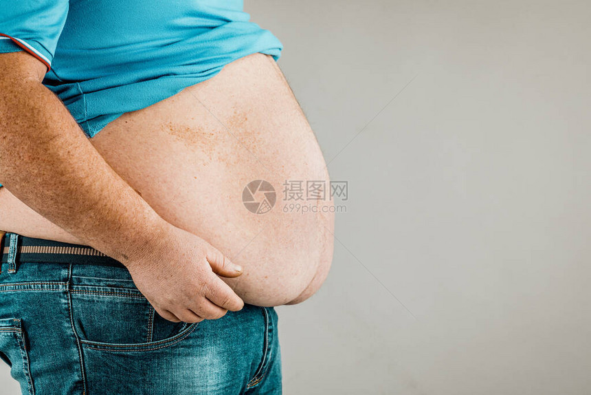 人的身体超重双手触摸腹部肥胖的概念图片