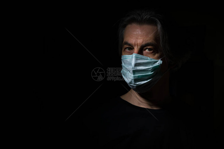 黑色背景上戴着医用口罩的成年男子的严峻肖像头孢感染期间自图片
