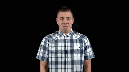 一个年轻人表现出悲伤的情绪身穿黑底衬衫的悲图片
