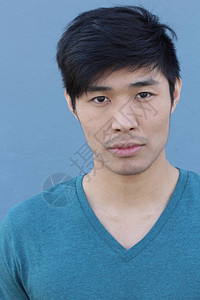 蓝墙前英俊年轻的亚洲男背景图片