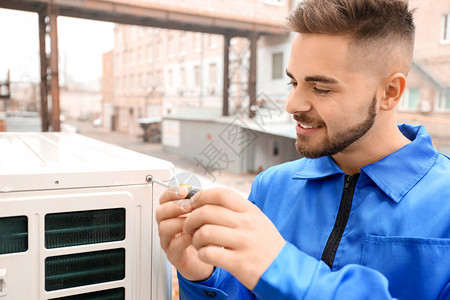 安装空调室外机的男技师图片