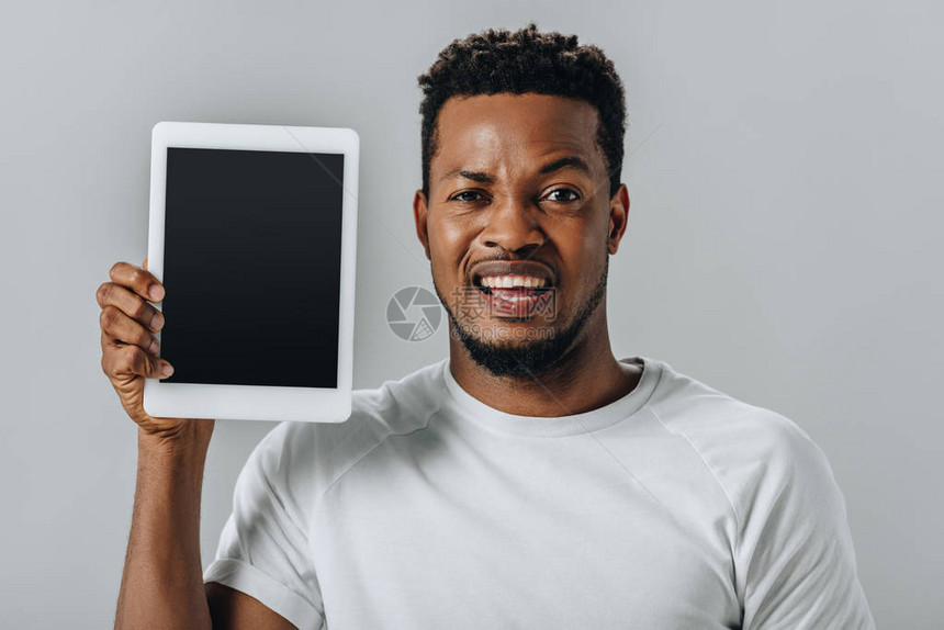 心烦意乱的非裔美国人男子拿着数字平板电脑图片
