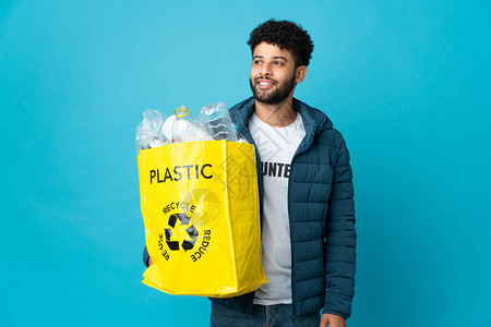 年轻摩洛哥男子拿着一袋装满塑料瓶的塑料瓶图片