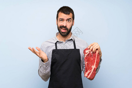 拿着生肉做怀疑姿态的厨师图片