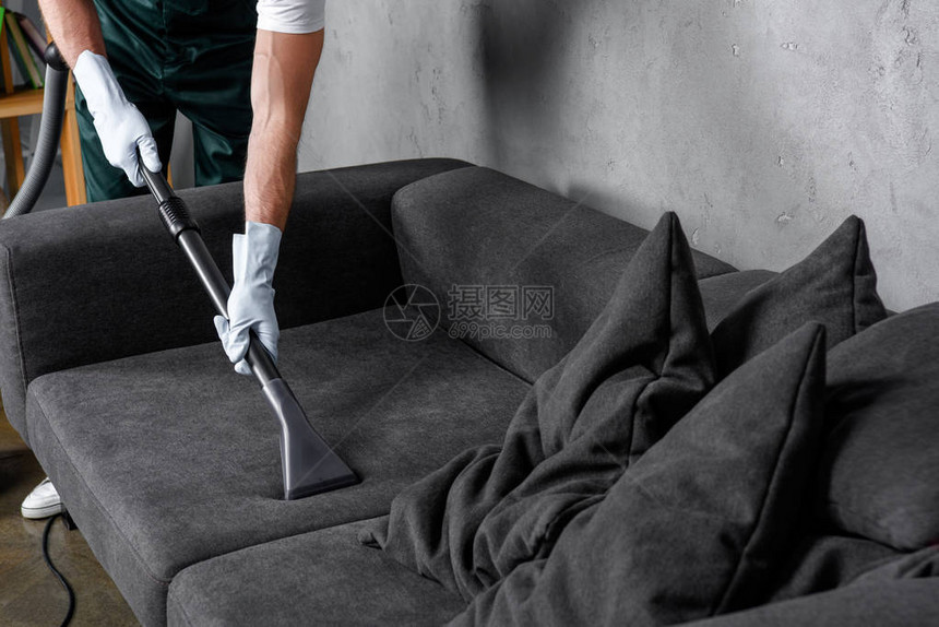 使用吸尘清洁和清洁沙发用橡胶手套拍图片