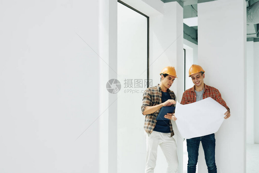两位专业建筑工程师站在未完工的房间里图片