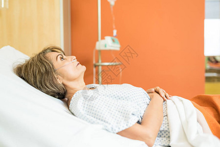 女病人躺在医院床上等待医生时的侧面视线请看女高清图片