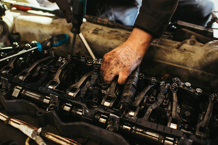 汽车修理工在发动机上工作图片