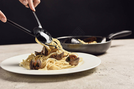 将美味的意大利意大利意面和海产食品放在盘子上的黑图片