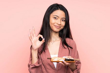 年轻亚裔女孩吃寿司时图片
