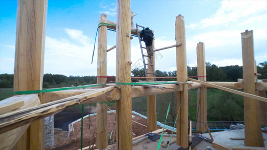 男建筑工人在农村从事木墙施工一个木房子的未完成的图片
