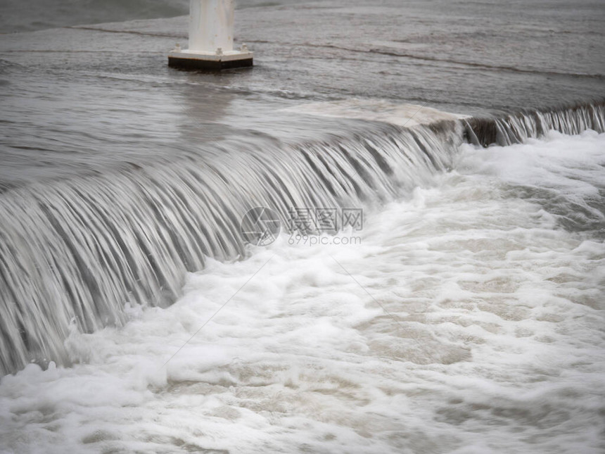 在芝加哥密歇根湖的混凝土码头边缘紧贴地看到水层积聚或瀑布在风日里当海浪图片