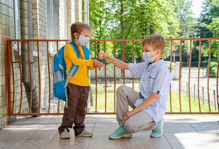 学童一个男孩和一个女孩站在学校门口附近图片