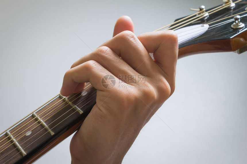 吉他玩家手或音乐手在C大和弦在近视中以软自然光显示图片