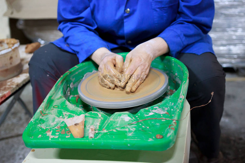 陶艺第一课的新学生试图在陶器轮子上用粘土制成产品报告手图片