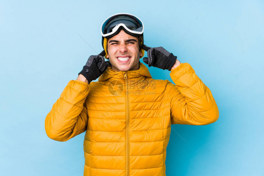 身穿滑雪衣的年轻滑雪男子戴着滑雪板护目镜图片