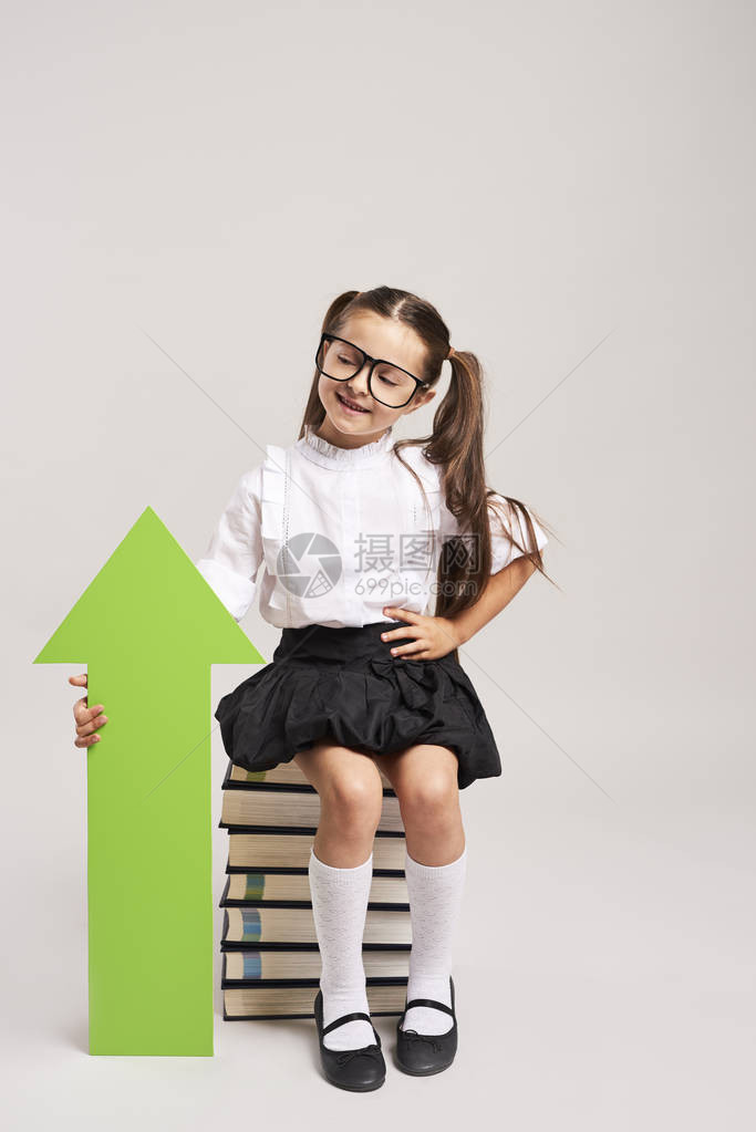 坐在书上的升箭头的女孩图片