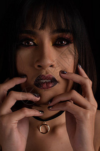以黑色背景的暗色音调化妆的东南亚女图片