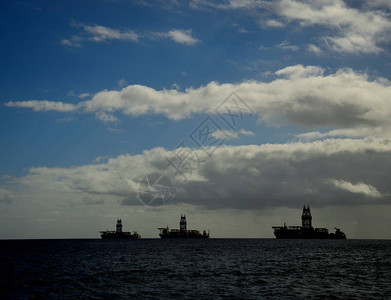 海湾的3个石油平台黎明后蓝天图片
