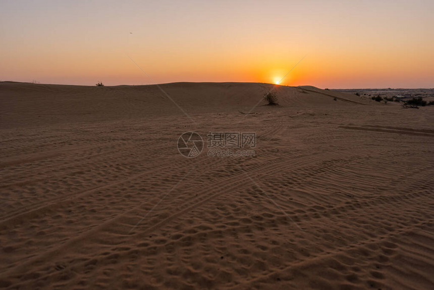 日落时迪拜沙漠的风景图片