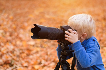 金发小男孩用SLR摄像机拍图片