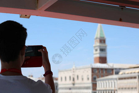 男孩用手机拍摄威尼斯圣马可的坎帕尼莱Camp背景图片