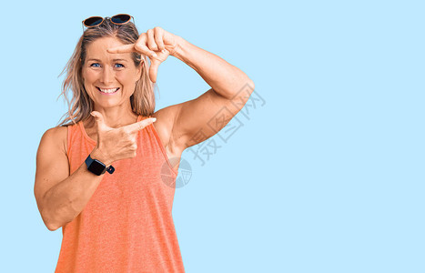 中年金发碧眼的金发女子身着临时暑期服装和太阳镜图片