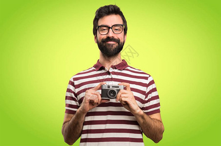 带着眼镜的快乐男人拿着相机图片