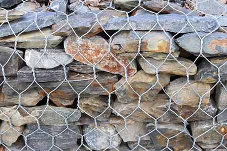 钢网状铁栅栏中的石图片
