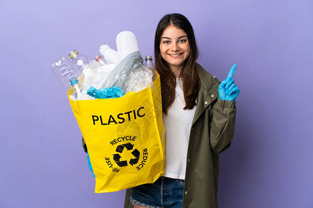年轻女士拿着一袋装满塑料瓶的塑料瓶图片