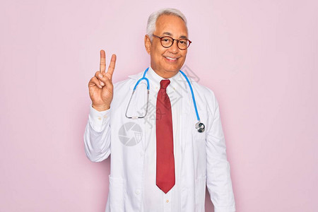 身着听诊镜和专业医疗大衣的中年老灰头发医生男子展示和指着二号手指图片