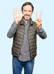 中年英俊男子穿着冬衣露面用七号手指举起手来微笑着自信图片