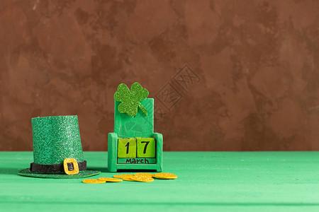日期为3月17日的历绿色背景上的妖精帽子和三叶草圣帕特里克节庆祝概念复制空背景图片