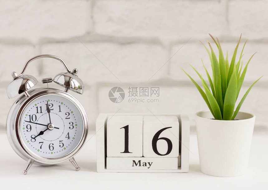 5月16日在木制日历上每月的天日历和闹钟在浅色背景上院子里的春天图片